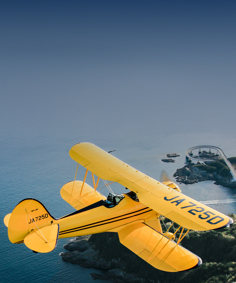 yellow plane flying above water
