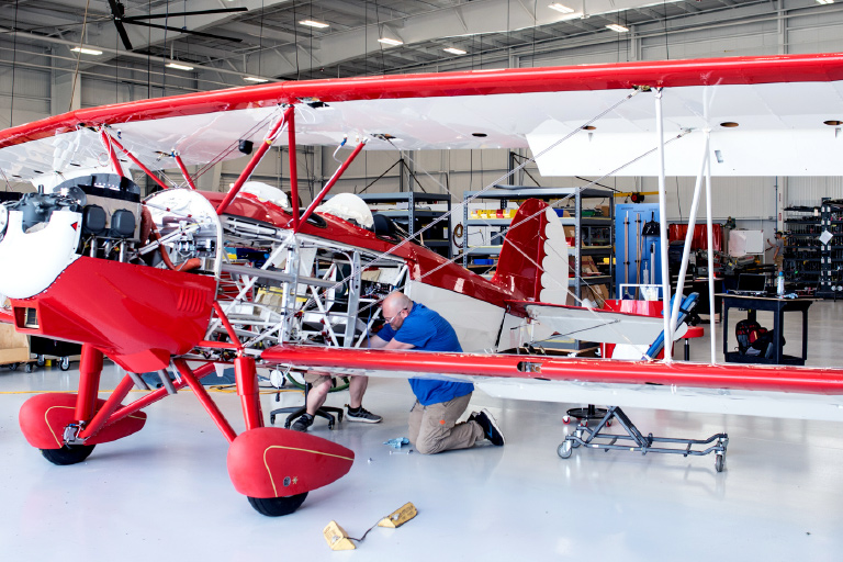 aircraft mechanic working in WACO shop on biplane